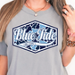 A woman wearing a gray t-shirt with a graphic design that says "Blue Tide Long County".
