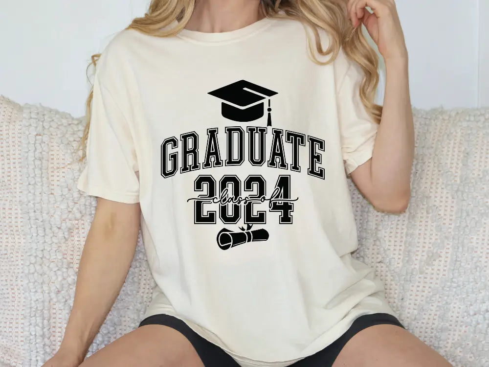 a woman sitting on a couch wearing a graduation shirt