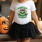 a little girl wearing a pumpkin shirt and a tutu skirt