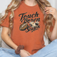 a woman sitting on a couch wearing a t - shirt with a football on it