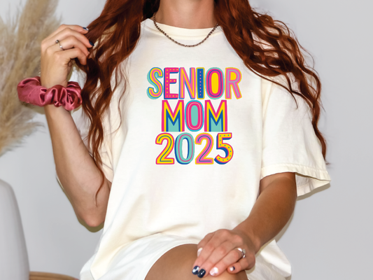 a woman with long red hair wearing a t - shirt that says senior mom 205