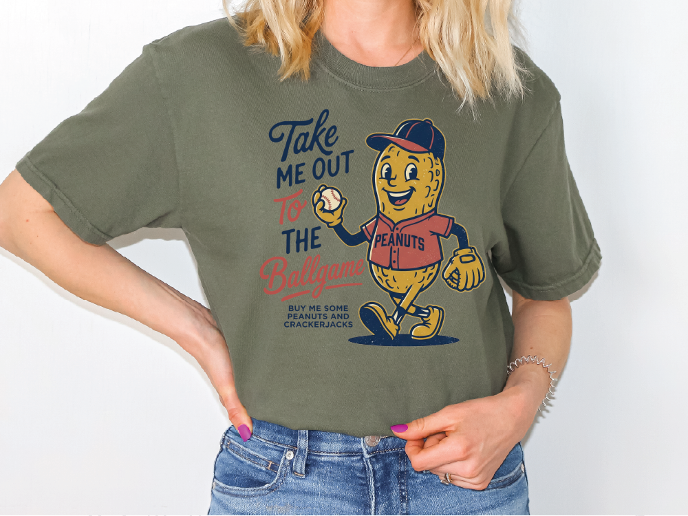 A person wearing a green t-shirt with a cartoon peanut character and text printed on it.