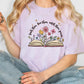 a woman sitting on the floor holding a book