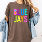 A person wearing a brown t-shirt with the text "BLUE JAYS" in colorful letters, along with a denim jacket, stands against a white background.