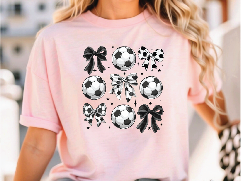 a woman wearing a pink shirt with soccer balls on it