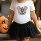 a little girl wearing a mickey mouse shirt