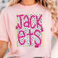 A woman wearing a pink t-shirt with a graphic design featuring the word "JACK" in pink and black text, surrounded by a pattern of black and white polka dots.