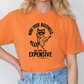 a woman wearing an orange shirt with a raccoon on it