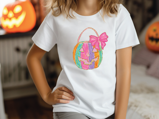 a little girl wearing a white t - shirt with a basket on it