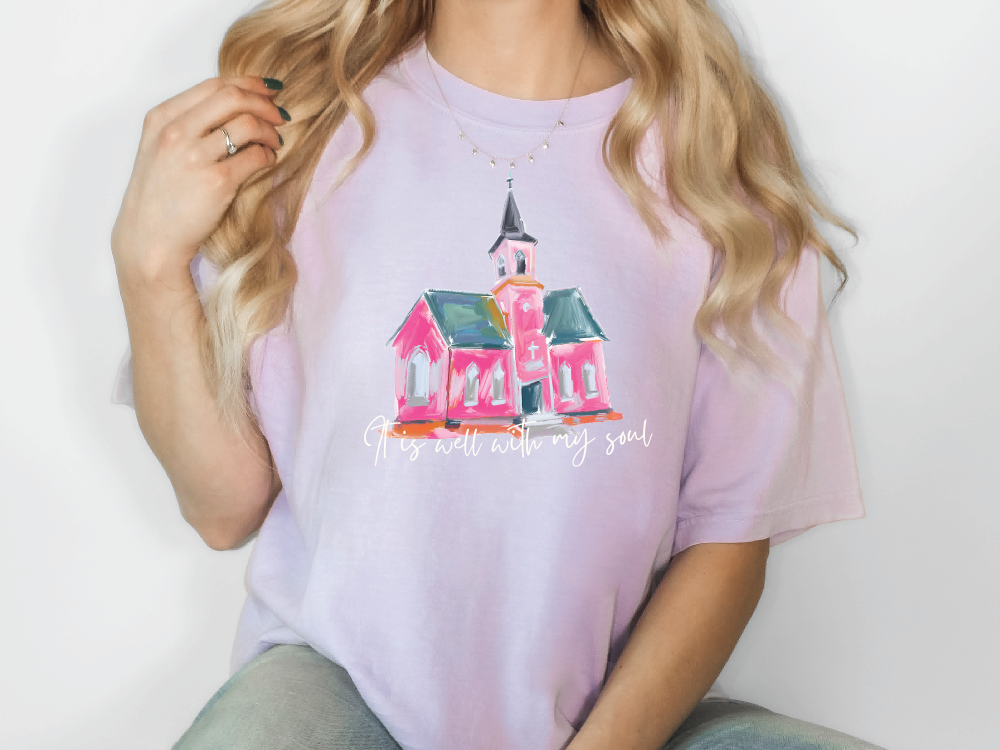 a woman wearing a pink t - shirt with a pink church on it