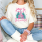 a woman sitting on a couch wearing a t - shirt that says joy to the