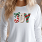 A woman wearing a white long-sleeved shirt with the word "Joy" embroidered on it.