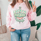 a woman wearing a pink sweatshirt and jeans