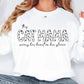 a woman wearing a white sweatshirt with the words cat mama printed on it
