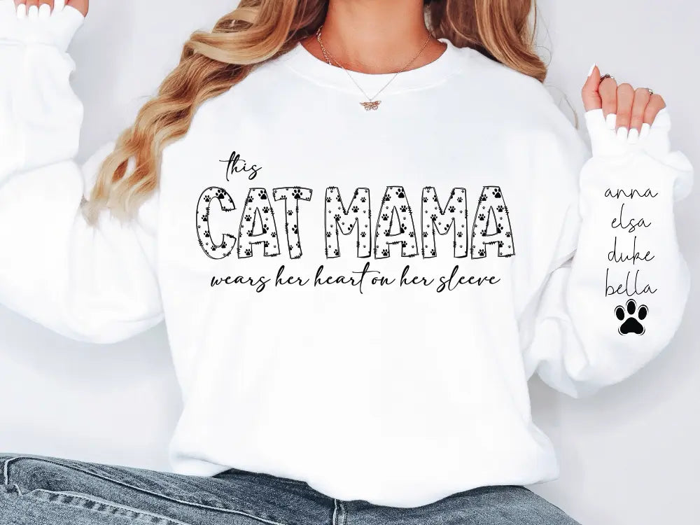 a woman wearing a white sweatshirt with the words cat mama printed on it