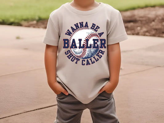 a young boy wearing a t - shirt with a baseball on it