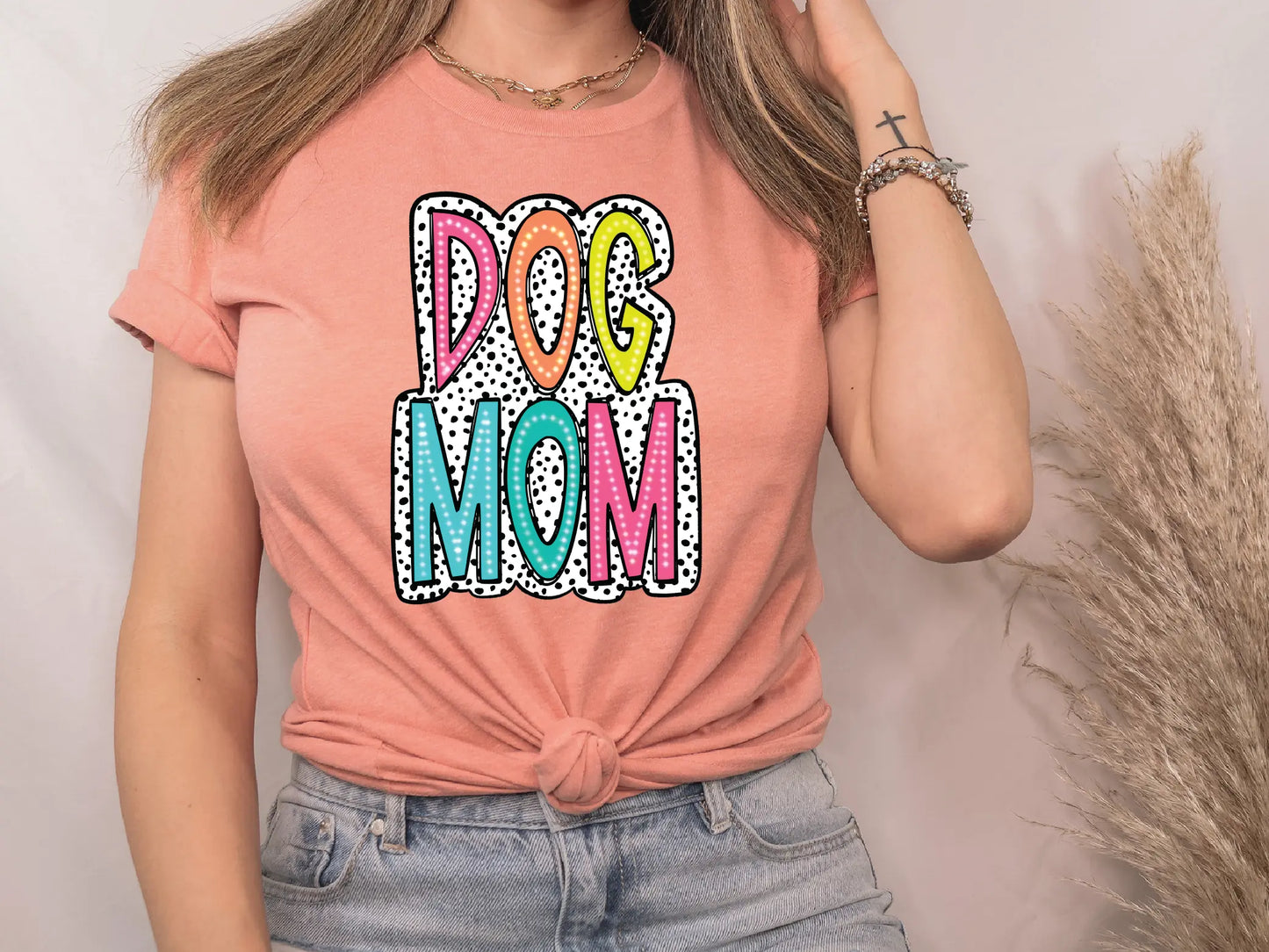 a woman wearing a dog mom t - shirt while talking on a cell phone