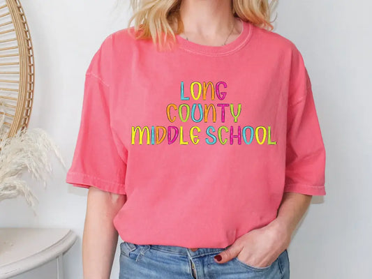 a woman wearing a pink long county middle school t - shirt