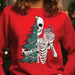 a woman wearing a red shirt with a skeleton holding a christmas tree