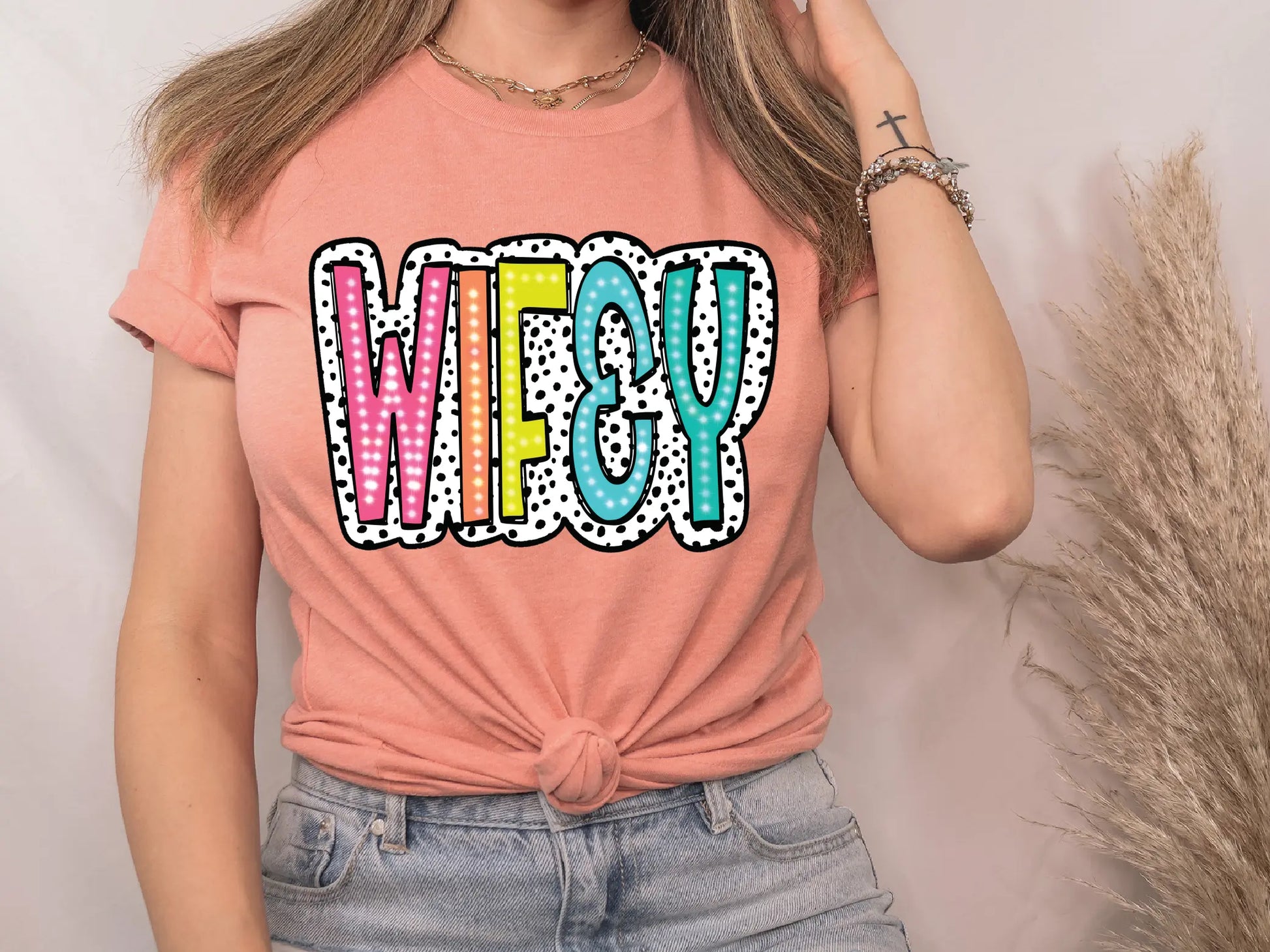 a woman wearing a pink shirt with the word weezy on it