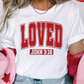 a woman wearing a white shirt with the word loved printed on it