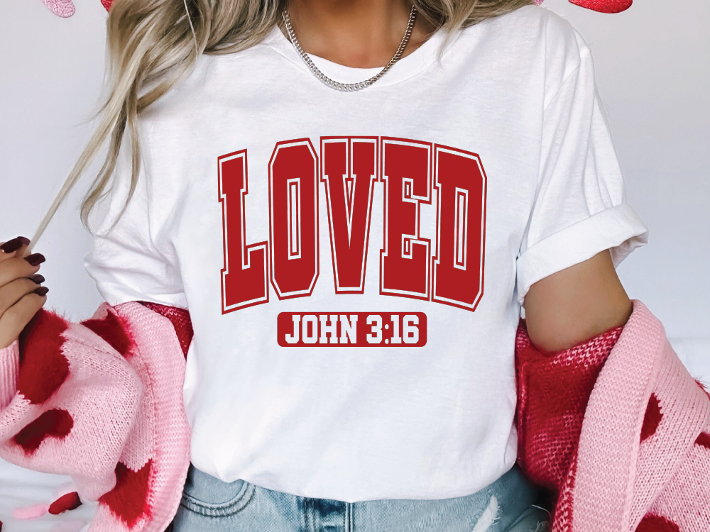 a woman wearing a white shirt with the word loved printed on it