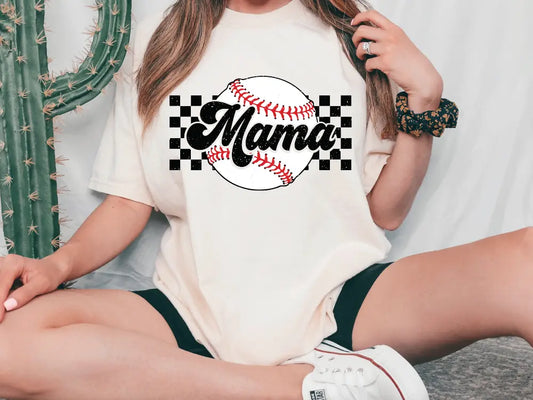 a woman sitting on the ground with a baseball on her shirt