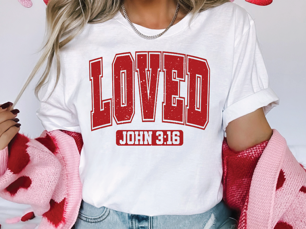 a woman wearing a t - shirt with the word loved printed on it