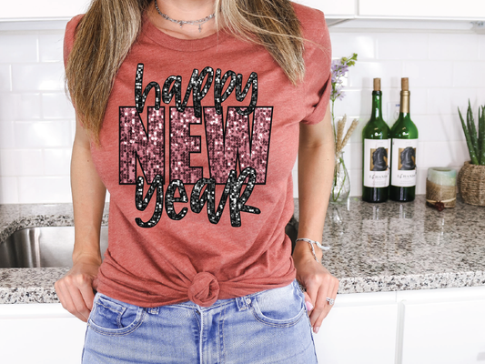 a woman standing in a kitchen wearing a happy new year shirt