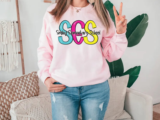 a woman wearing a pink sweatshirt with the word sos on it