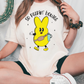 a woman sitting on the ground wearing a t - shirt with a pikachu