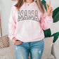 a woman wearing a pink sweatshirt with the word mama on it
