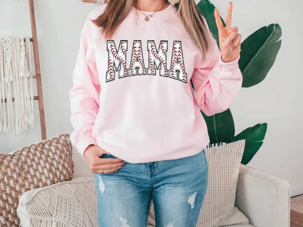 a woman wearing a pink sweatshirt with the word mama on it