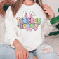 a woman sitting on a couch wearing a teacher bunny sweatshirt