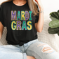 a woman sitting on a couch wearing a mardi gras shirt