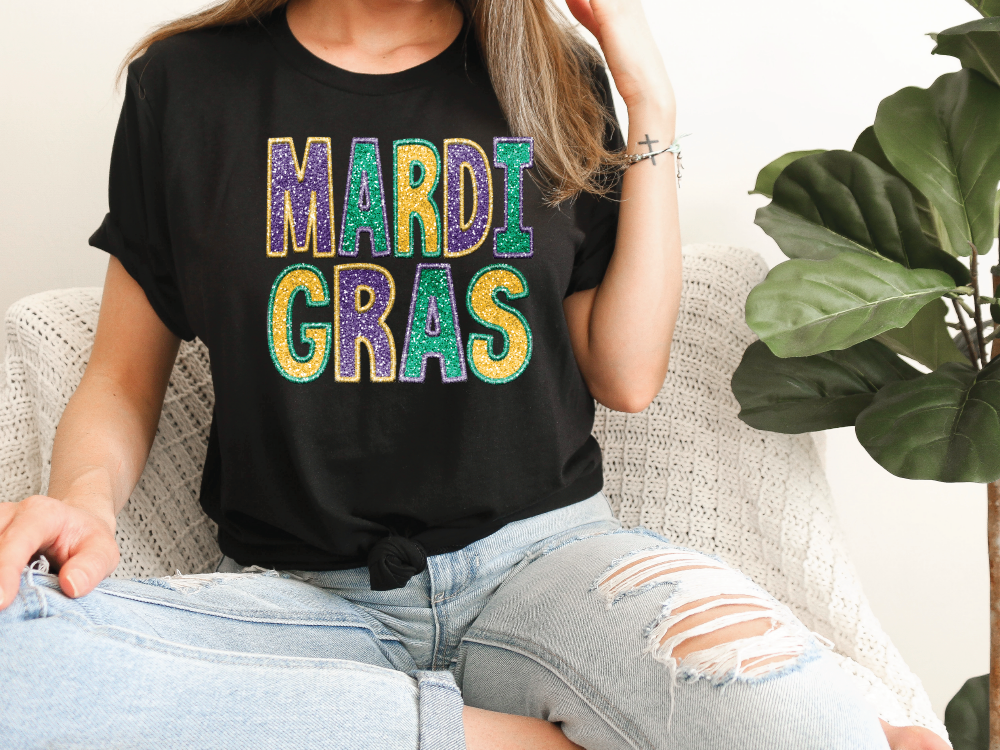 a woman sitting on a couch wearing a mardi gras shirt