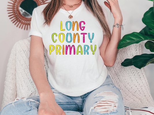 a woman sitting on a couch wearing a long county primary t - shirt