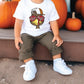 a little boy sitting on a step next to pumpkins