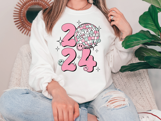 a woman sitting on a couch wearing a happy new year sweatshirt