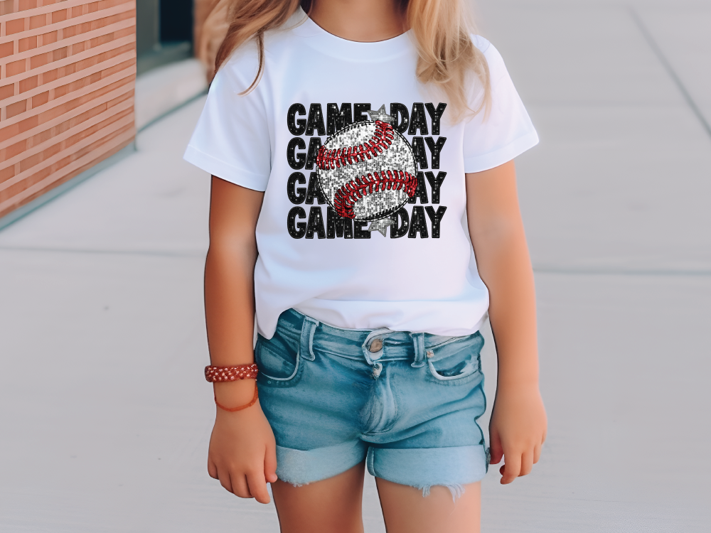a little girl wearing a white shirt with a baseball on it