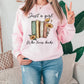 a woman wearing a pink sweatshirt that says just a girl who loves books