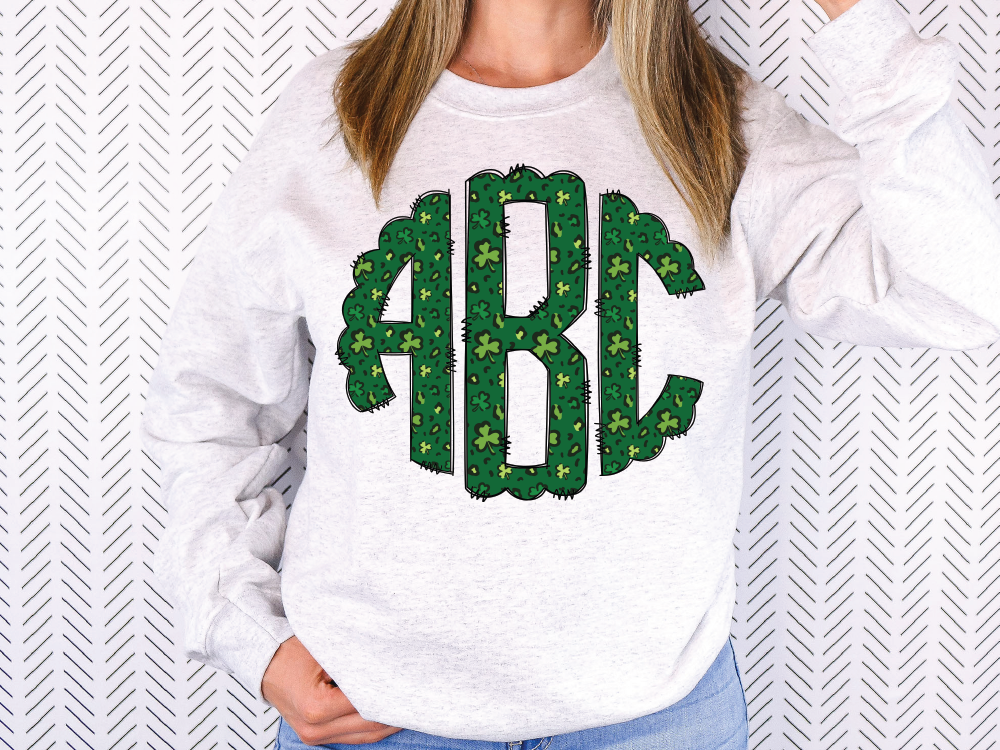 a woman wearing a white sweatshirt with a green monogrammed turtle on it