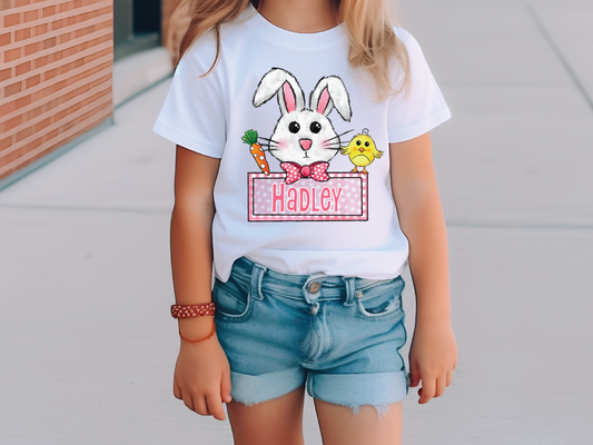 a little girl wearing a happy easter bunny t - shirt