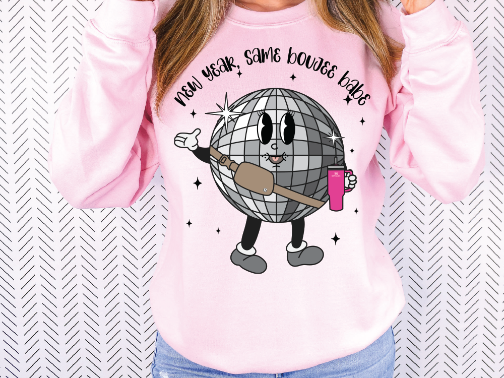 a woman wearing a pink sweater with a cartoon character on it