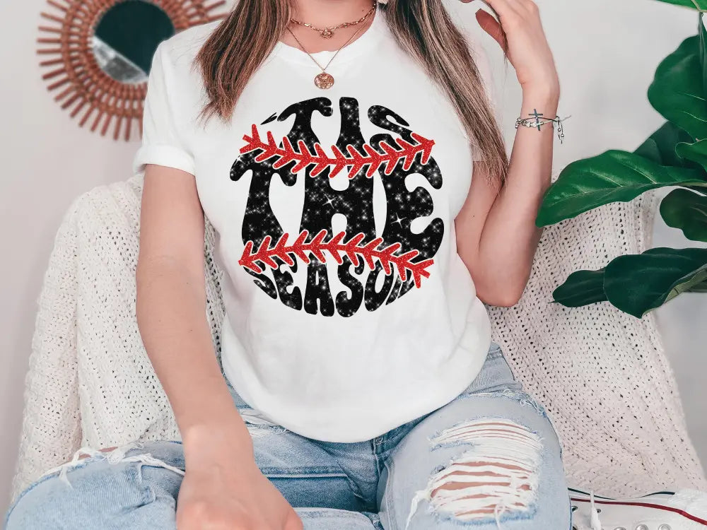 a woman sitting on a couch wearing a baseball shirt