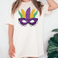 a woman wearing a t - shirt with a mardi gras mask on it