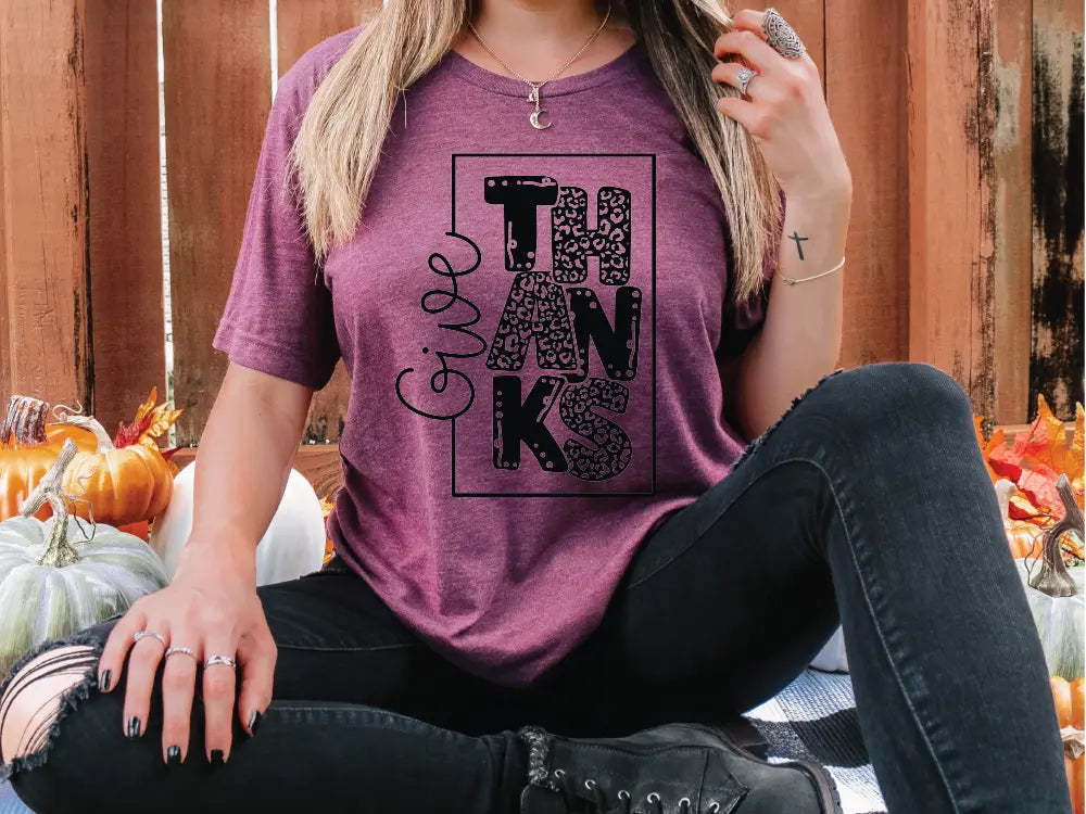 a woman sitting on the ground wearing a purple shirt