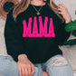 a woman sitting on a couch wearing a black sweatshirt with pink letters