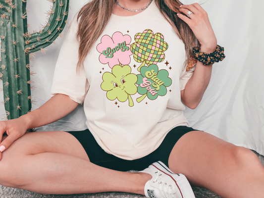 a woman sitting on the ground wearing a t - shirt with shamrocks on it