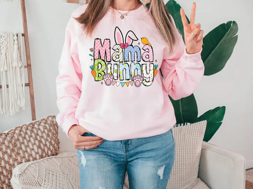 a woman wearing a pink sweatshirt that says mama bunny